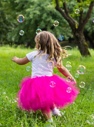 Girl chasing bubble blower