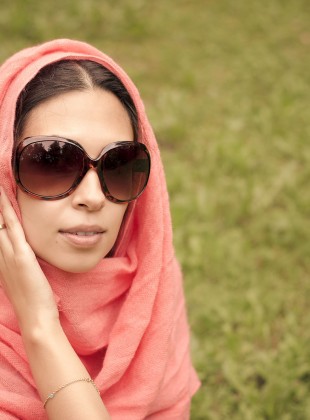 Beautiful arabian girl in shawl and sun glasses.