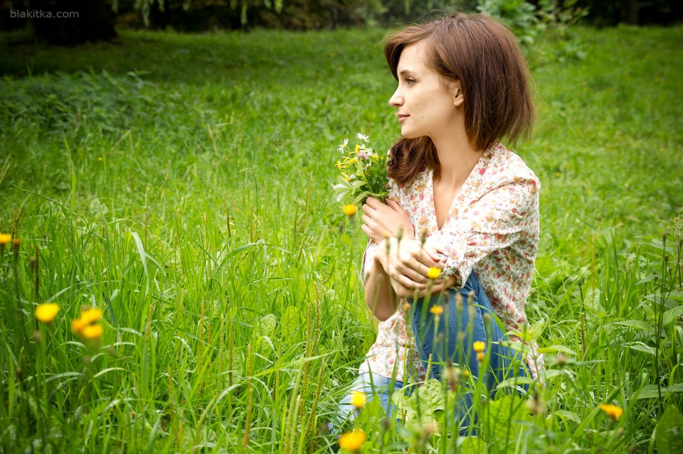 Girl in grass with bouquet of wild flowers