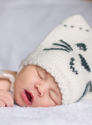 Newborn baby in a kitty hat. 11 days.