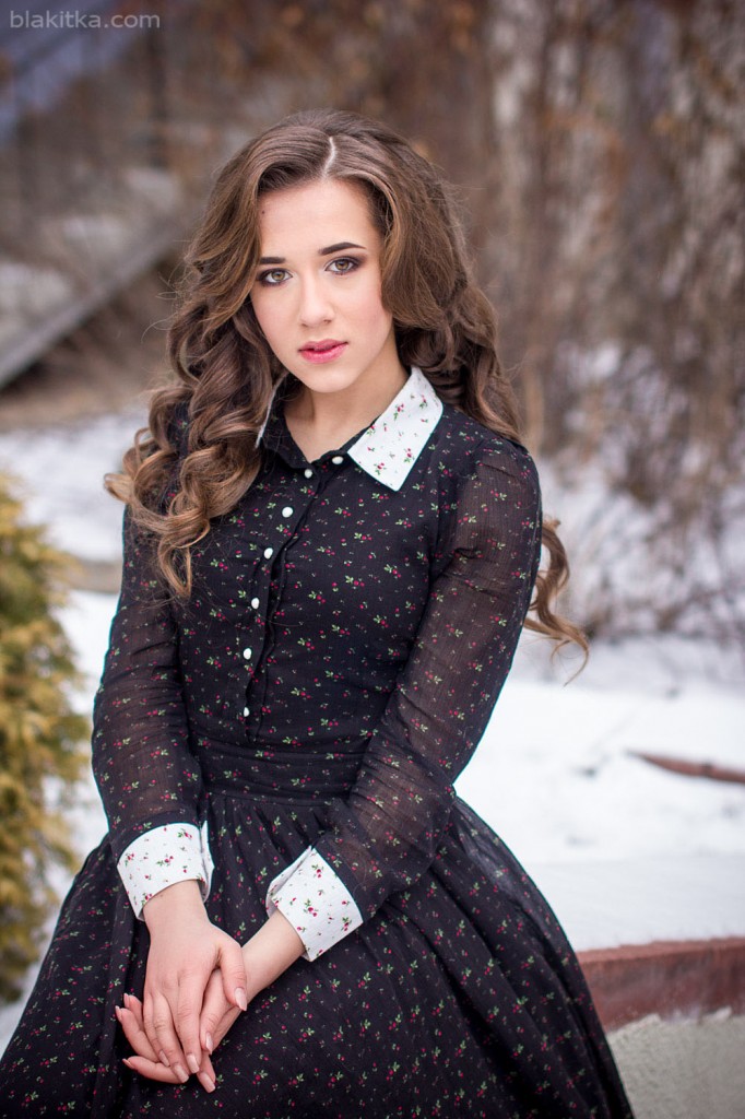winter portrait of a beautiful girl in a long dress with snow